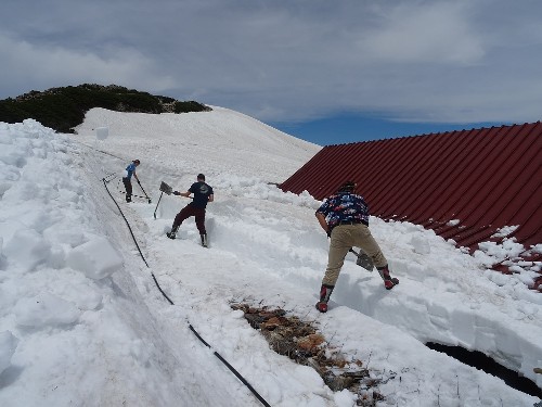 03537<br />
” class=”alignnone” /></div>
<p>この陽気で午前中から除雪作業や布団干し。長靴履いてのこの時期の除雪作業は、体全体が汗ばみます。ちなみに、この除雪場所は本館の屋根。木造の建物ゆえ、真上からの雪の重みはなんとか凌げても、横から加わる重みには弱い、つまり今本館の建物は、歪んでいる状態で、それを何とか一日も早く解消してあげなくてはなりません。<br />
しかし、この汗ばむ陽気も手伝って、何とか屋根の際を全て出すことができたので、とりあえず一安心。この屋根の上に乗っかっている雪も無くなれば、小屋は徐々に起き上り、館内の開かない扉等が開くようになってくるんです。</p>
<p>さて明日はヘリコプターの空輸作業。今のところ明日も梅雨の中休み続きそうです。</p>
<p>
無事フライトなることを願いつつ、除雪での心地よい疲れを癒す、“缶ビール”で一杯といきましょうか・・・</p>
<nav class=